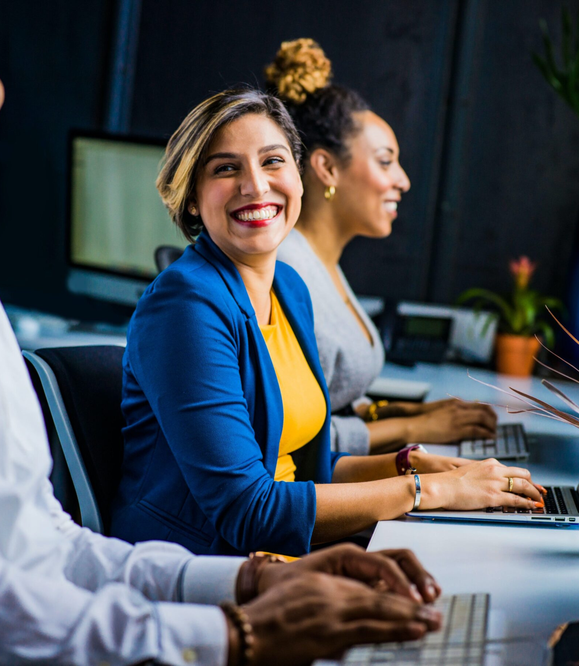 Smiling customer service agents working at computers